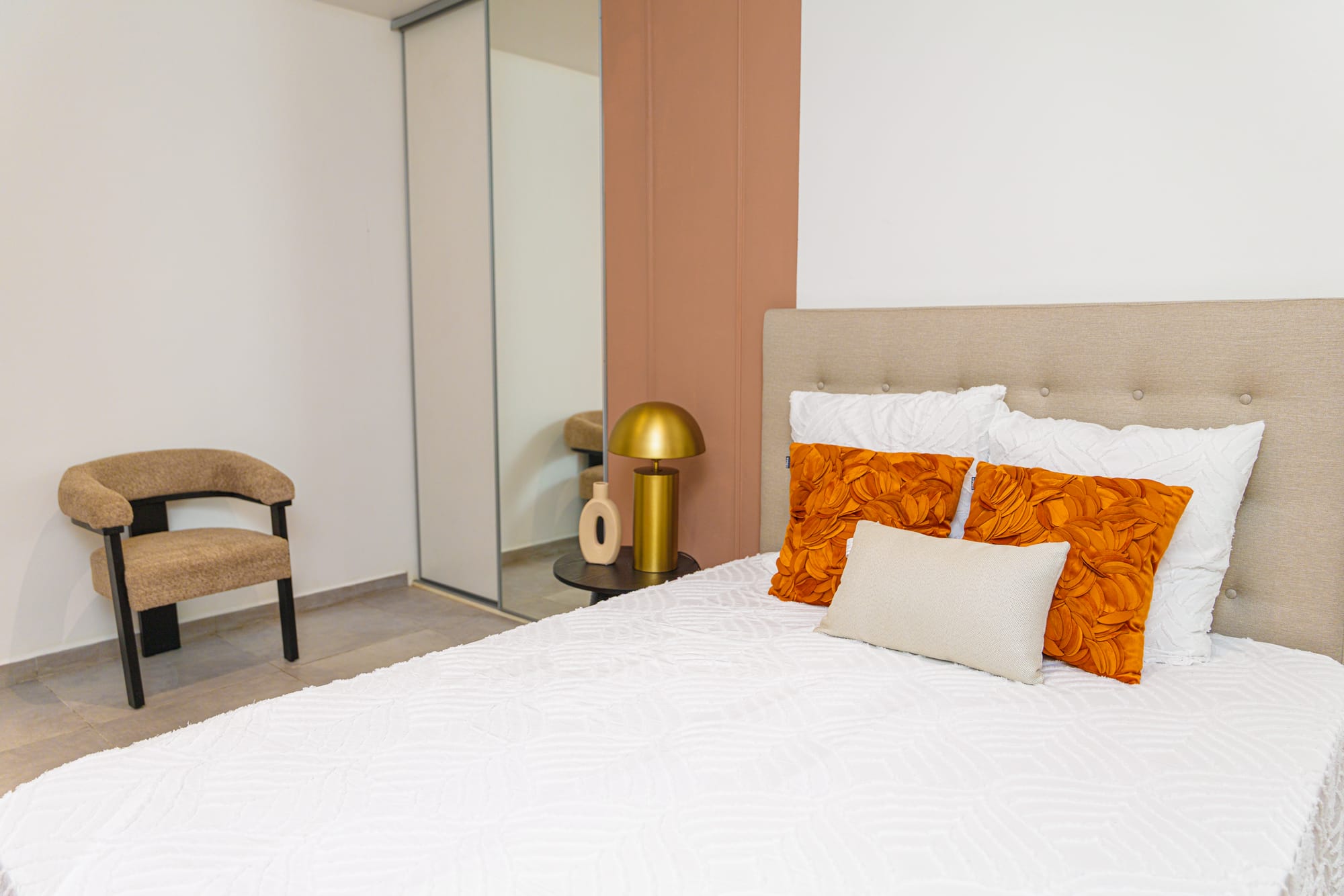Chambre aux accents orange et lampes dorées